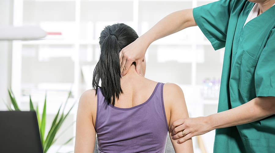 Chiropractor pinching a woman's neck and arm