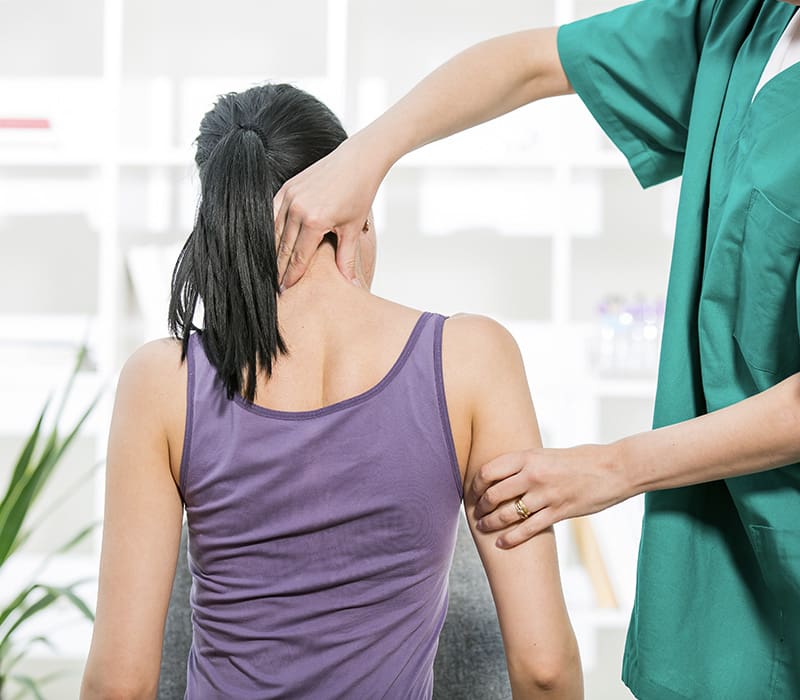 Chiropractor pinching a woman's neck and arm
